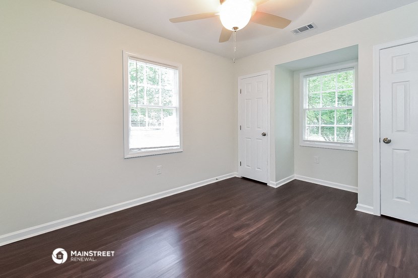 the living room of a house with wood floors and a ceiling fan