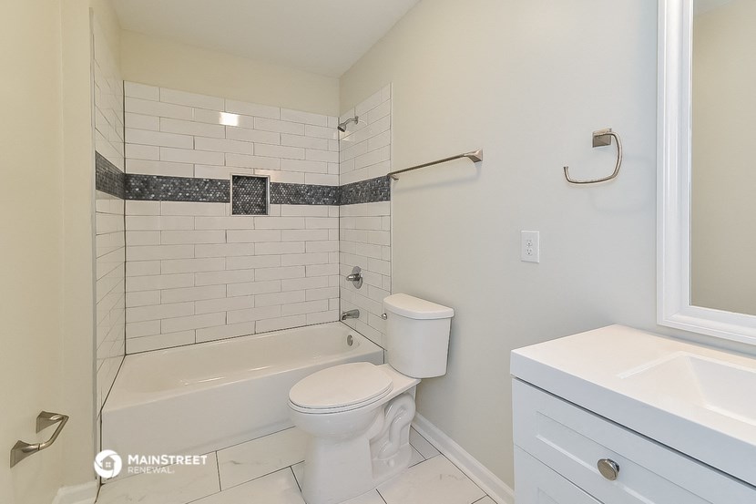 a bathroom with a tub and a toilet and a sink