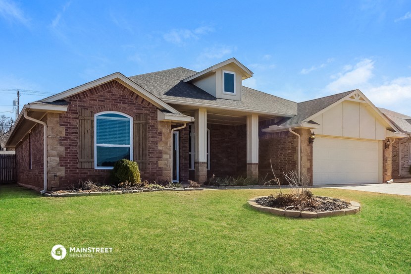 a brick house with a lawn and a driveway
