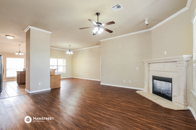 a living room with a fireplace and a ceiling fan