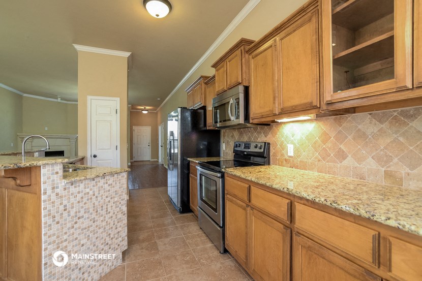 a kitchen with granite counter tops and black appliances