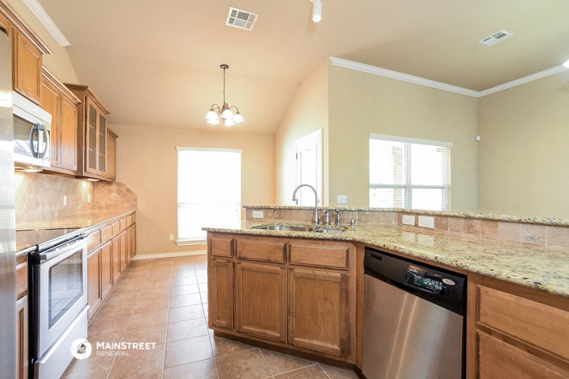 a kitchen with wooden cabinets and a granite counter top