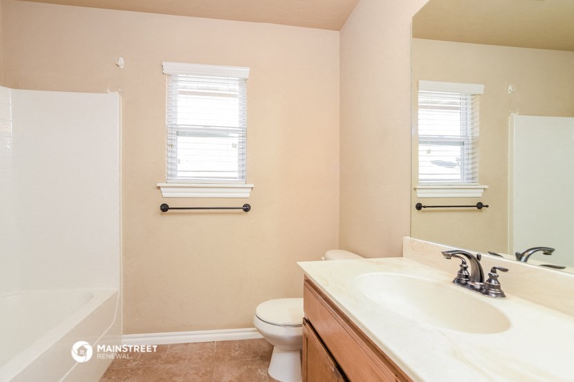 a full view of a bathroom with a toilet and a sink