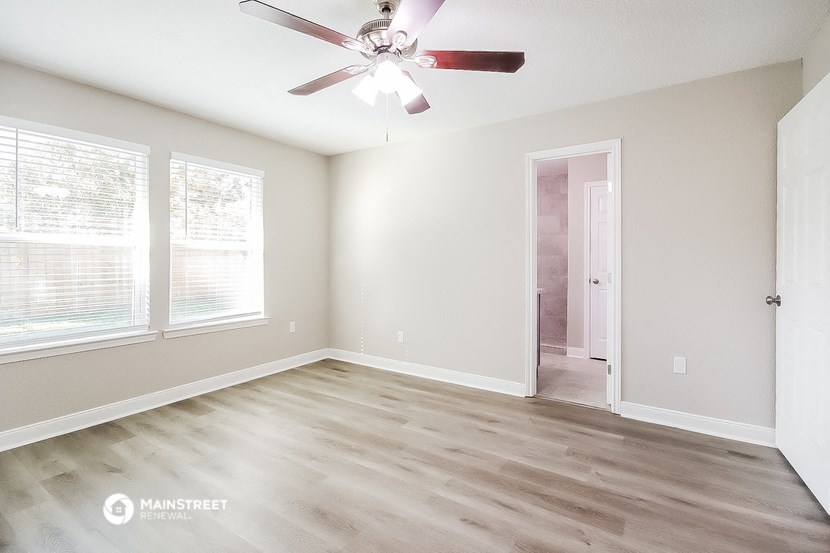 an empty room with a ceiling fan and a door to a closet