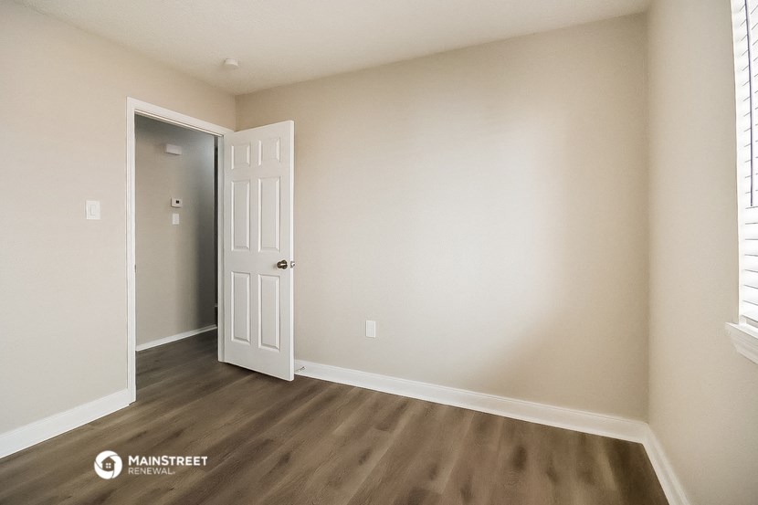 a bedroom with a white door and a door to a closet