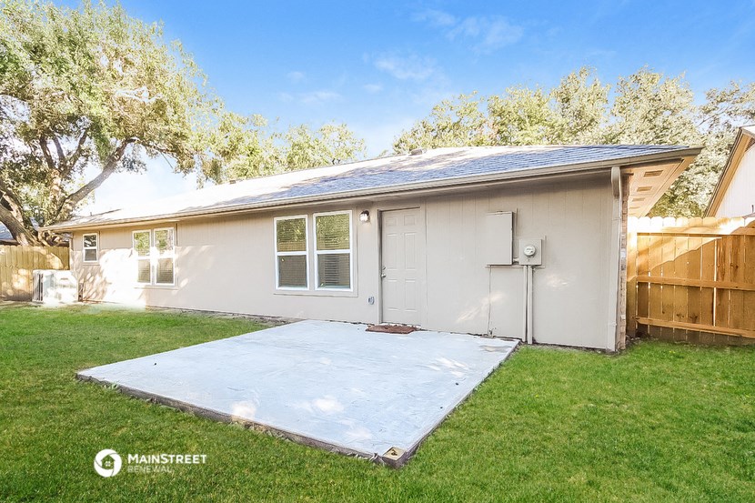 a small white house with a yard and a garage