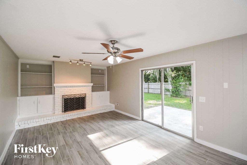 A spacious living room with a fireplace and sliding glass doors.