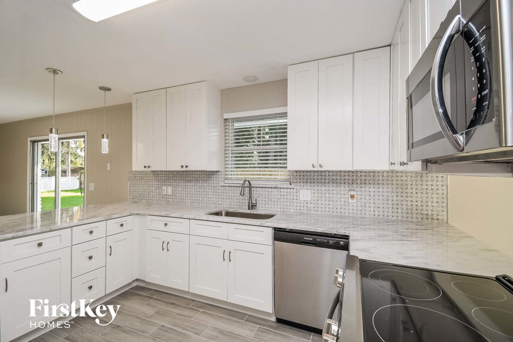 A kitchen with white cabinets and a stainless steel dishwasher.