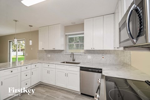 A kitchen with white cabinets and a stainless steel dishwasher.