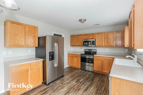 A kitchen with wooden cabinets and a refrigerator.