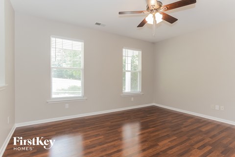 a living room with wood floors and a ceiling fan