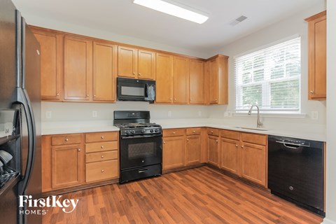 a kitchen with wooden cabinets and black appliances