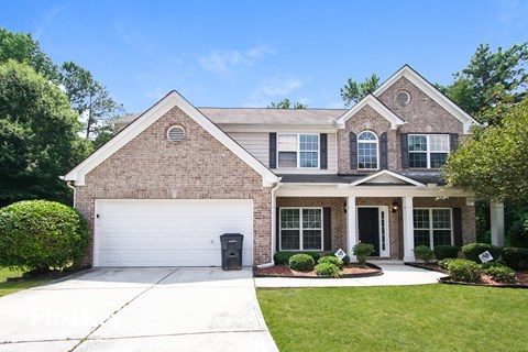 a brick house with a white garage door in front of it