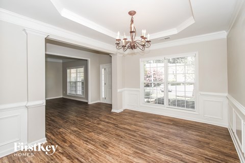 a dining room with a chandelier and a window