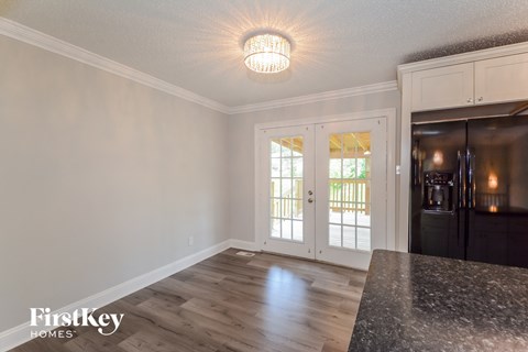 the kitchen of a home with white cabinets and a black counter top