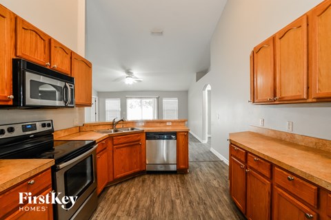 A kitchen with wooden cabinets and a stove top oven.