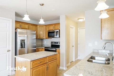 a kitchen with wooden cabinets and granite counter tops