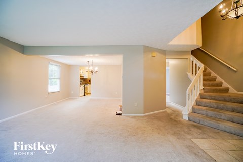 the living room and dining room with the staircase to the second floor