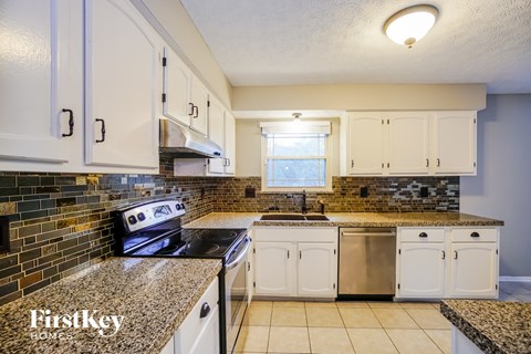 a kitchen with white cabinets and granite counter tops