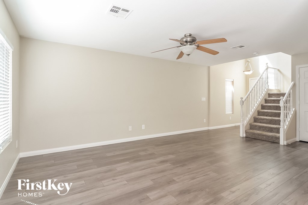 a living room with a staircase and a ceiling fan