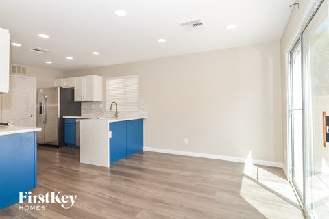a renovated kitchen with white and blue cabinets and a large window