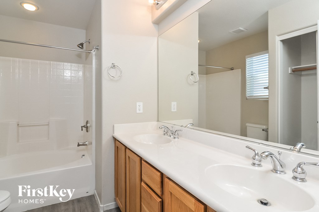 a bathroom with two sinks and a shower and a mirror