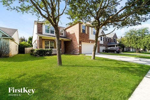 a home with a lawn and trees in front of it