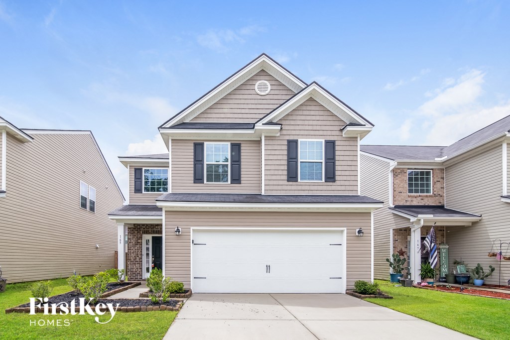 a beige and brown house with a white garage door