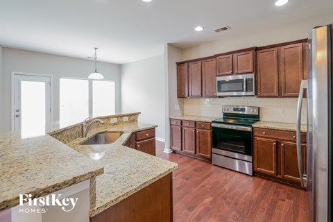 a kitchen with wooden cabinets and granite counter tops and stainless steel appliances