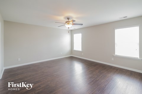 a living room with wood floors and a ceiling fan