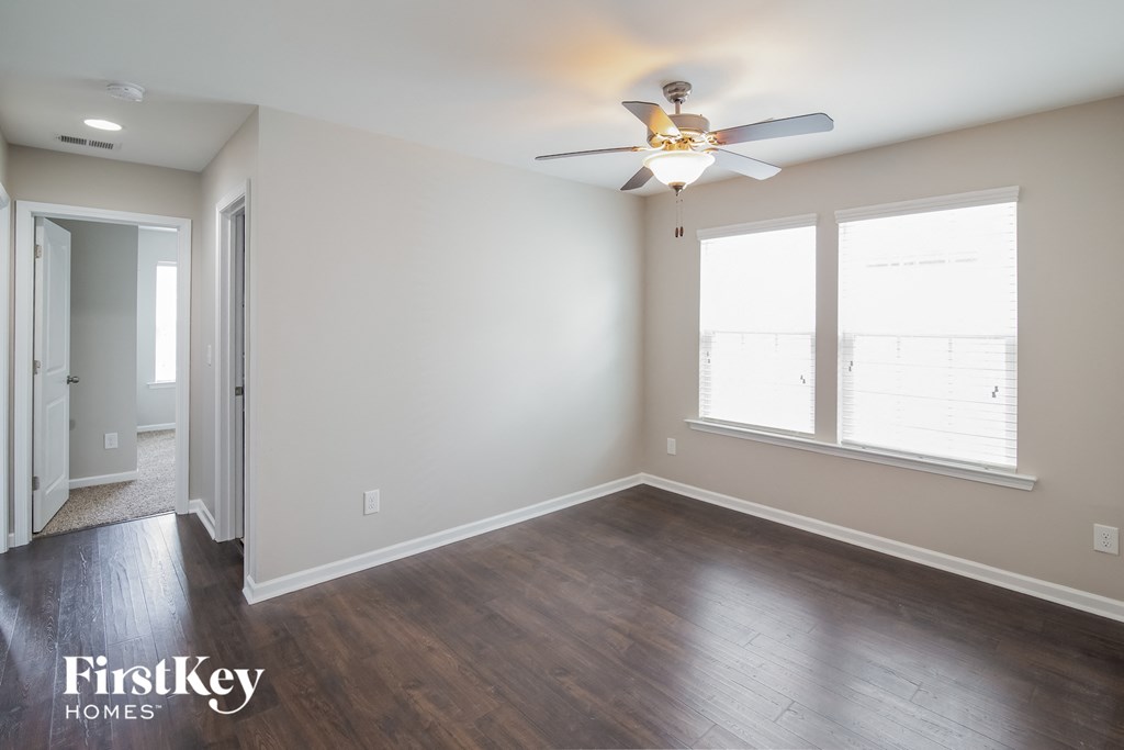 a living room with wood floors and a ceiling fan