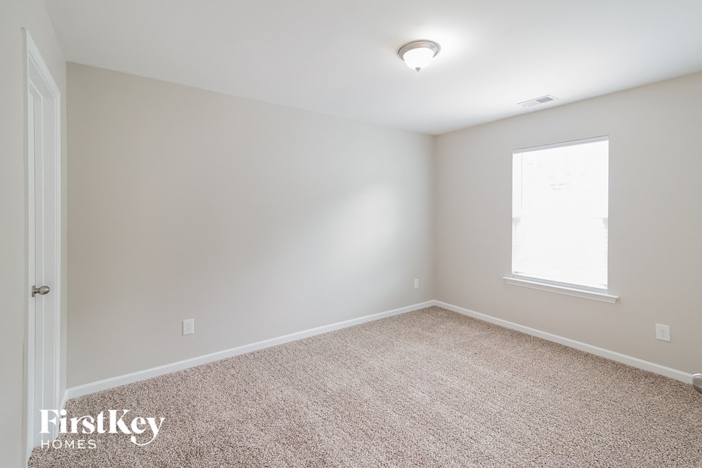 a bedroom with a carpeted floor and a window