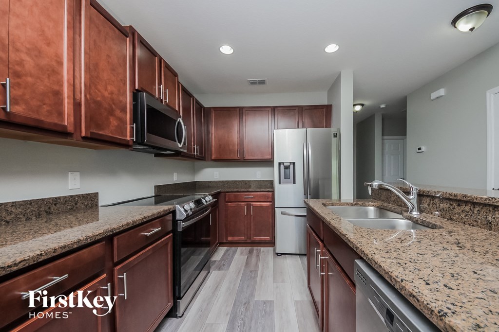 a kitchen with granite counter tops and wooden cabinets