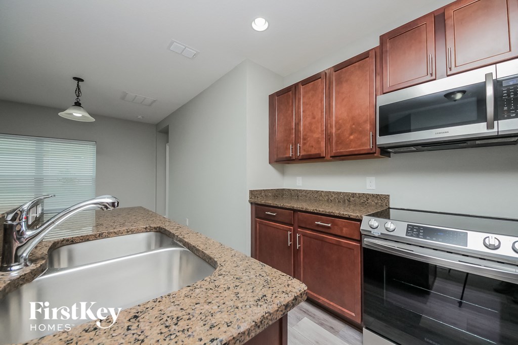 a kitchen with granite counter tops and stainless steel appliances