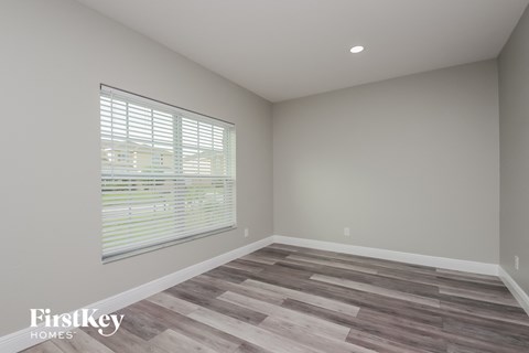 the living room of a new home with wood flooring and a large window