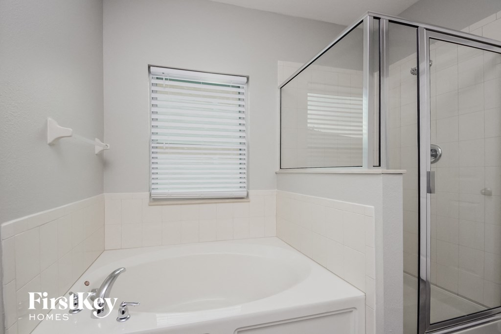 a white bathroom with a tub and a shower
