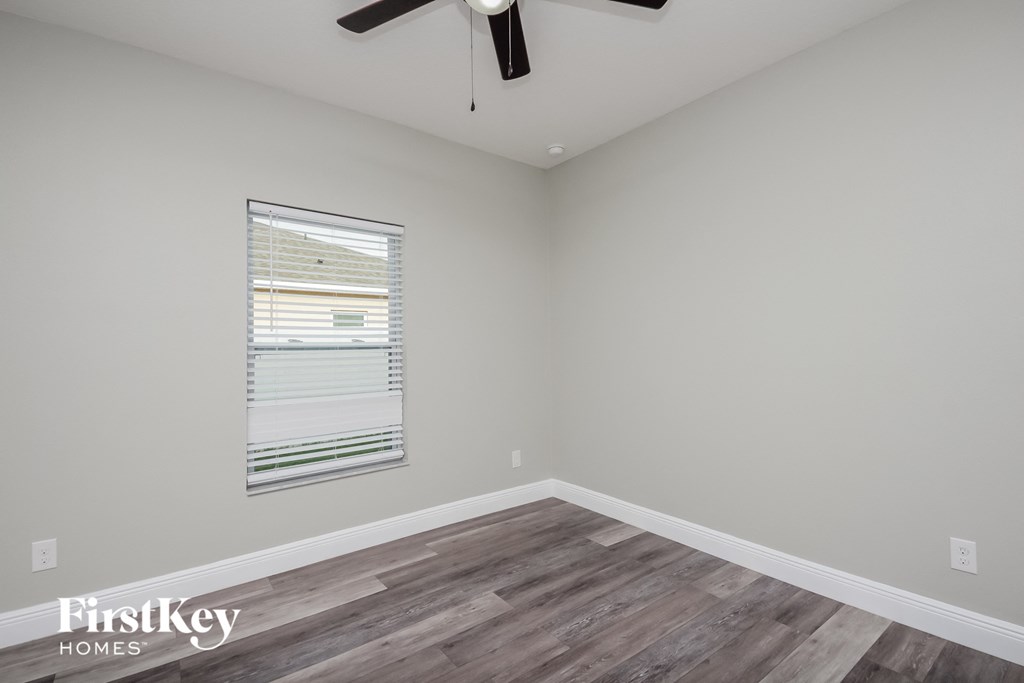the living room of a home with wood flooring and a ceiling fan