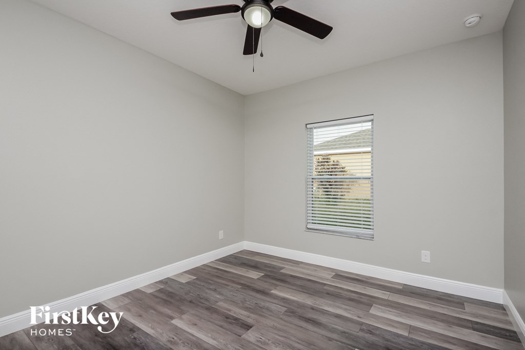the great room with wood flooring and a ceiling fan