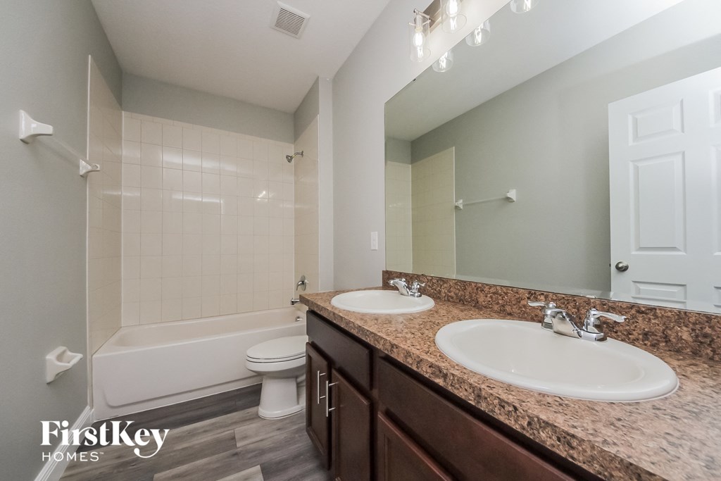 a bathroom with two sinks and a shower and a toilet
