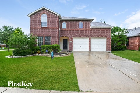 the front of a brick house with a white garage door
