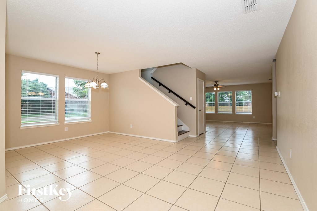 a living room with a staircase and a tiled floor