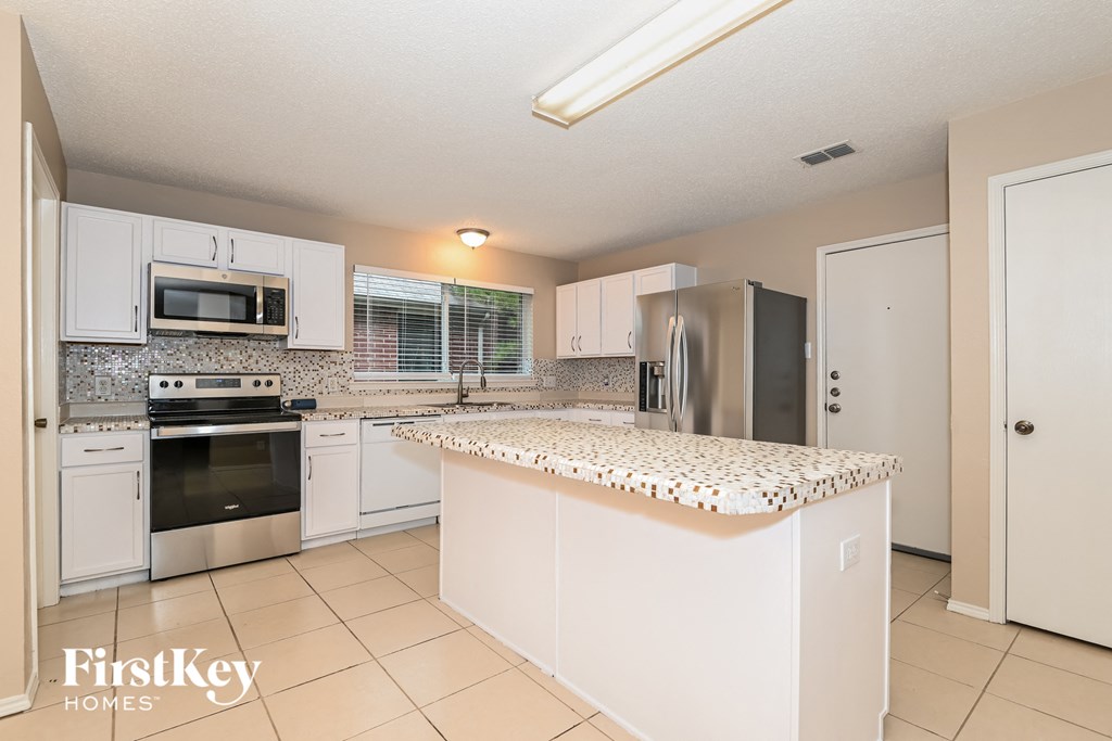 a kitchen with white cabinets and a counter top