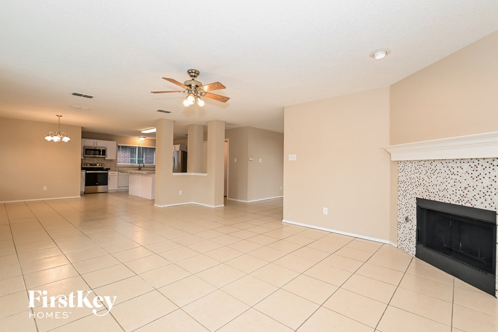 a large living room with a fireplace and a ceiling fan