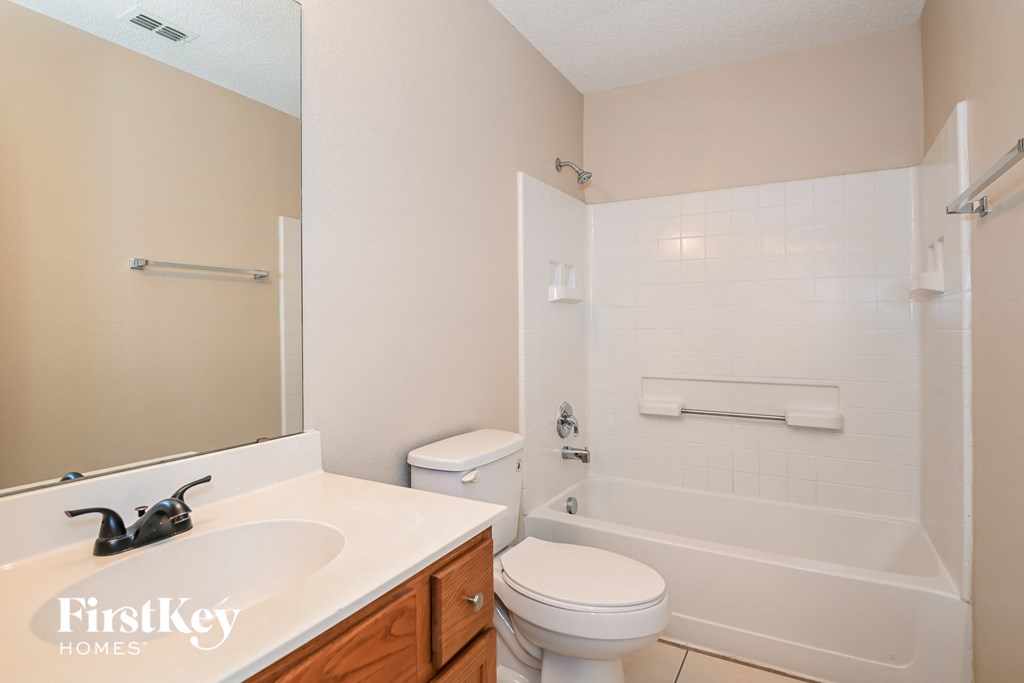 a bathroom with a toilet and a tub and a sink