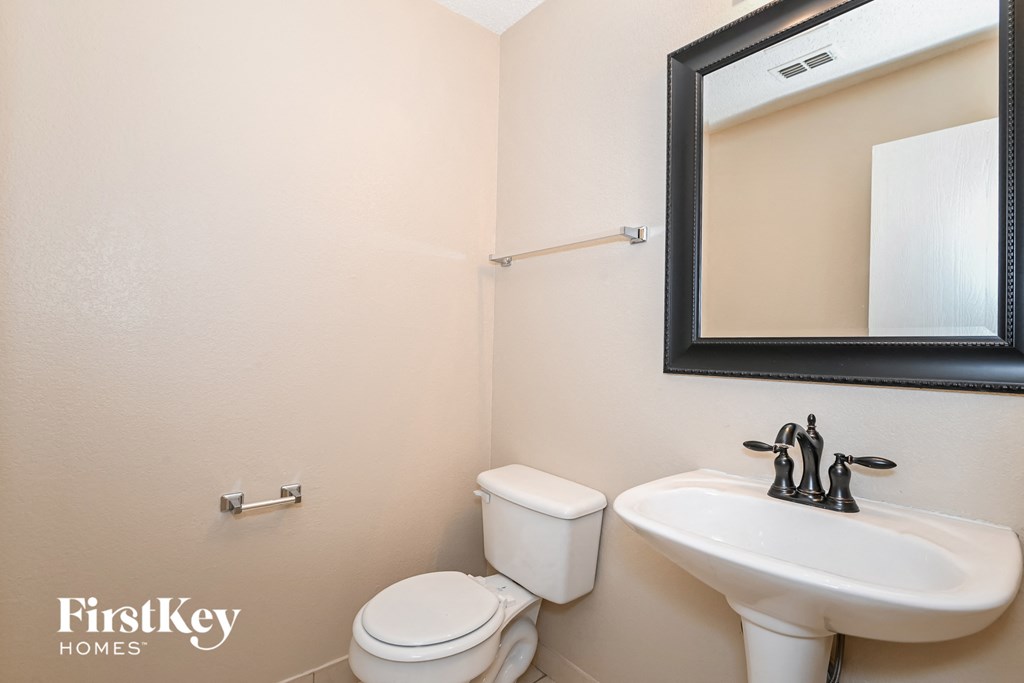 a bathroom with a sink toilet and a mirror