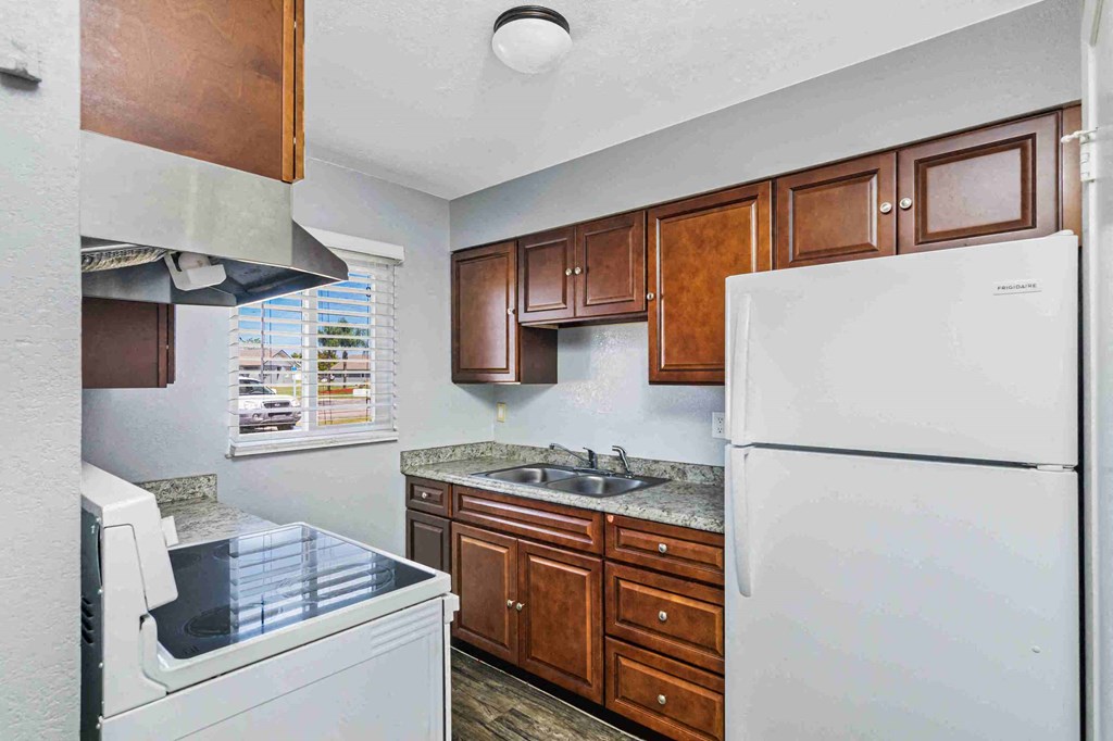 a kitchen with white appliances and wooden cabinets