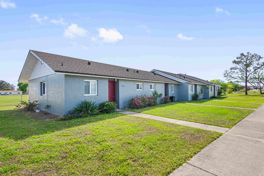 a row of houses on the side of a sidewalk