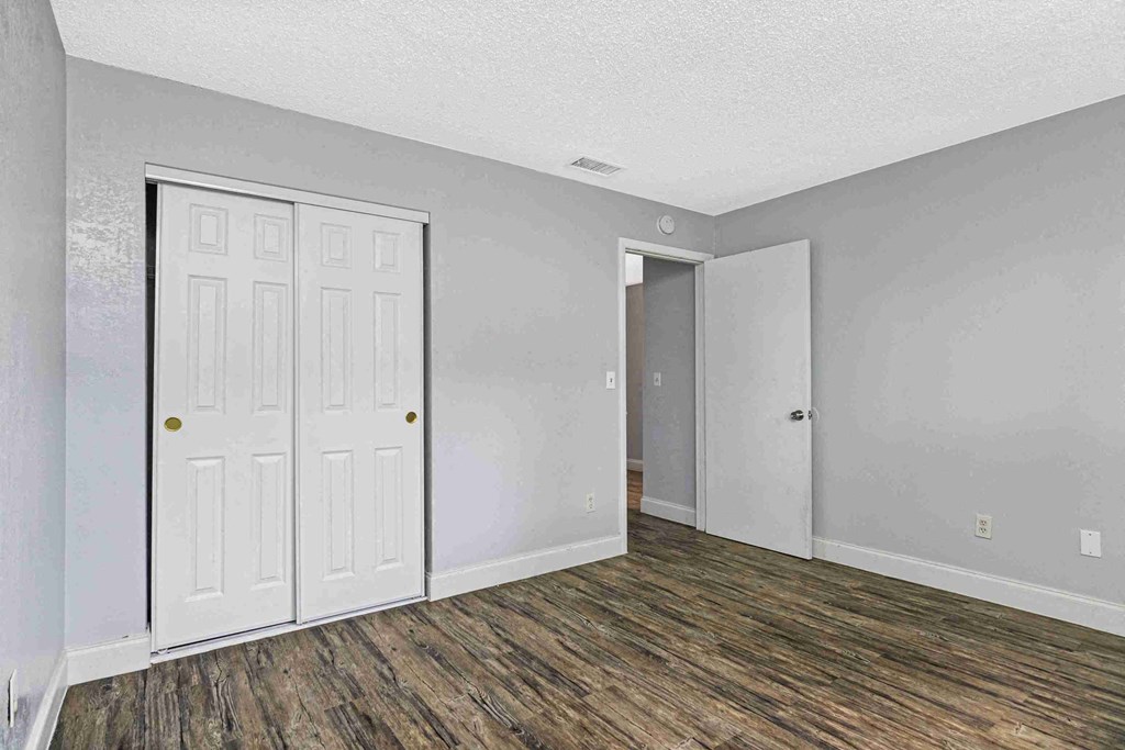 an empty living room with white walls and a door to a closet