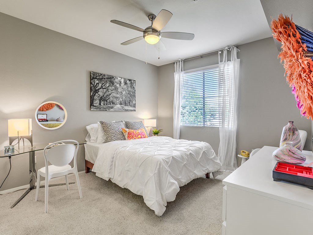 a bedroom with a bed and a ceiling fan
