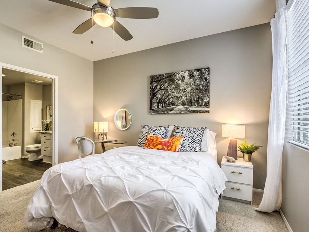 a bedroom with a bed and a ceiling fan